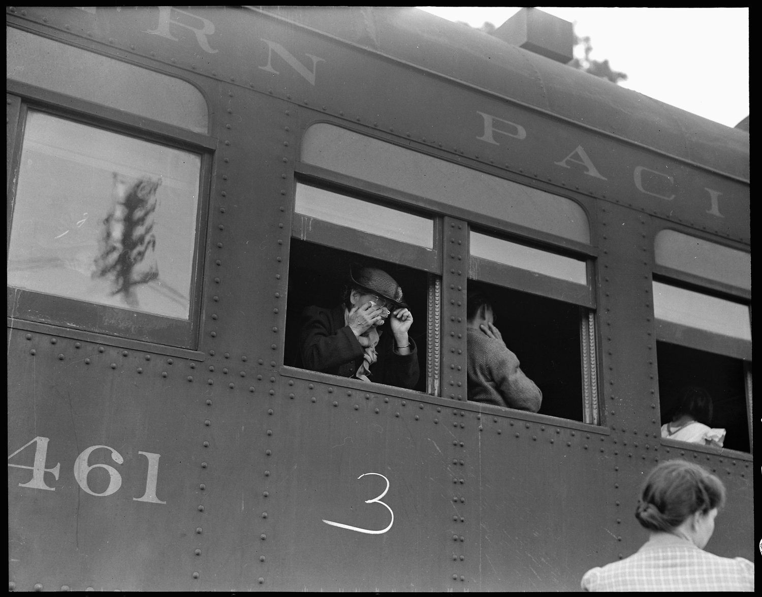 Woodland, Yolo County, California. Ten cars of evacuees of Japanese ancestry are now aboard and the doors are closed. Their Caucasian friends and the staff of the Wartime Civil Control Administration stations are watching the departure from the platform. Evacuees are leaving their homes and ranches, in a rich agricultural district, bound for Merced Assembly Center about 125 miles away.