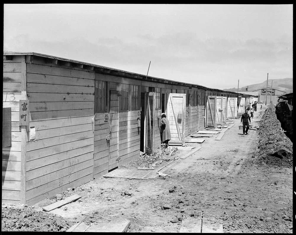 San Bruno, California. This scene shows one type of barracks for family use. These were formerly the stalls for race horses. Each family is assigned to two small rooms, the inner one, of which, has no outside door nor window. The center has been in operation about six weeks and 8,000 persons of Japanese ancestry are now assembled here.