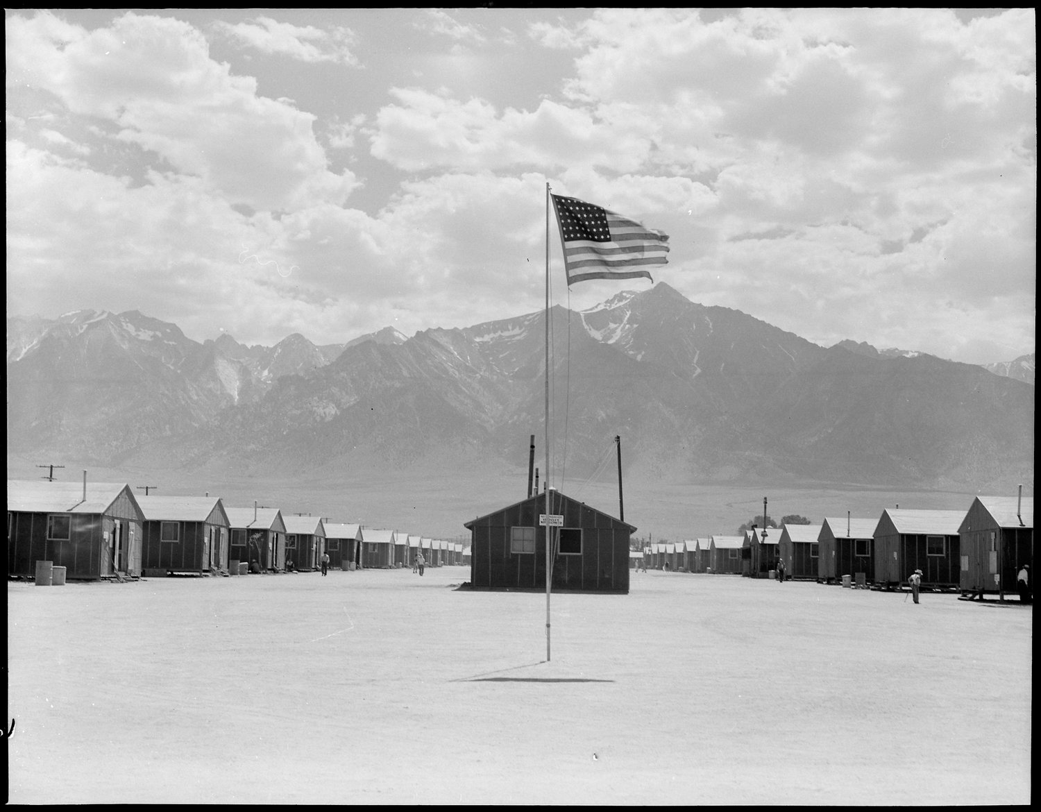 Manzanar Relocation Center, Manzanar, California. Street scene of barrack homes at this War Relocation Authority Center. The windstorm has subsided and the dust has settled.