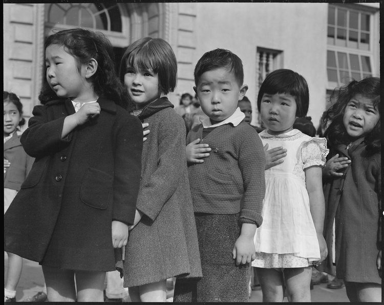 San Francisco, California. Many children of Japanese ancestry attended Raphael Weill public School, Geary and Buchanan Streets, prior to evacuation. This scene shows first- graders during flag pledge ceremony. Evacuees of Japanese ancestry will be housed in War Relocation Authority centers for the duration. Provision will be effected for the continuance of education.