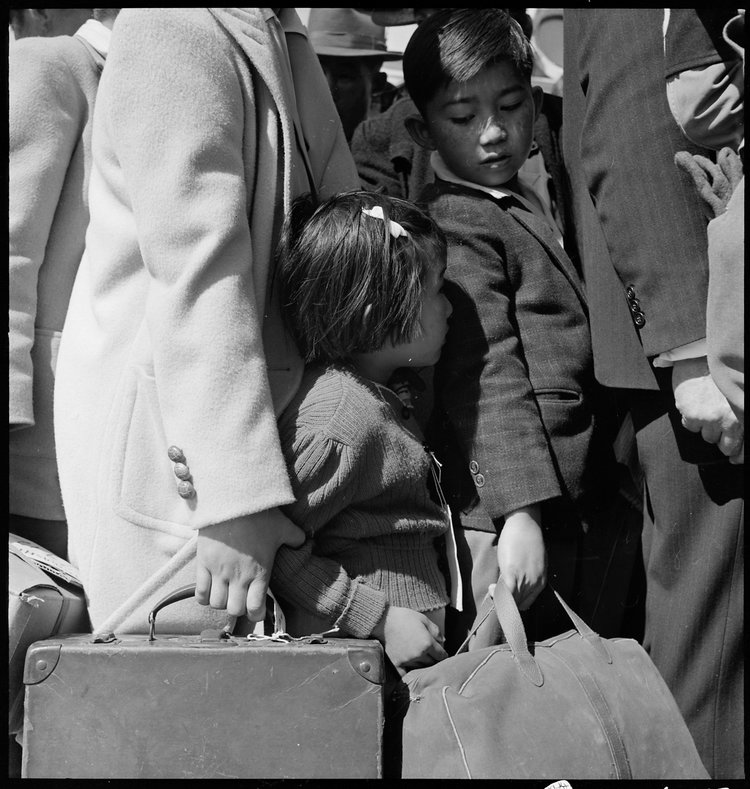 Byron, California. Third generation of American children of Japanese ancestry in crowd awaiting the arrival of the next bus which will take them from their homes to the Assembly center.