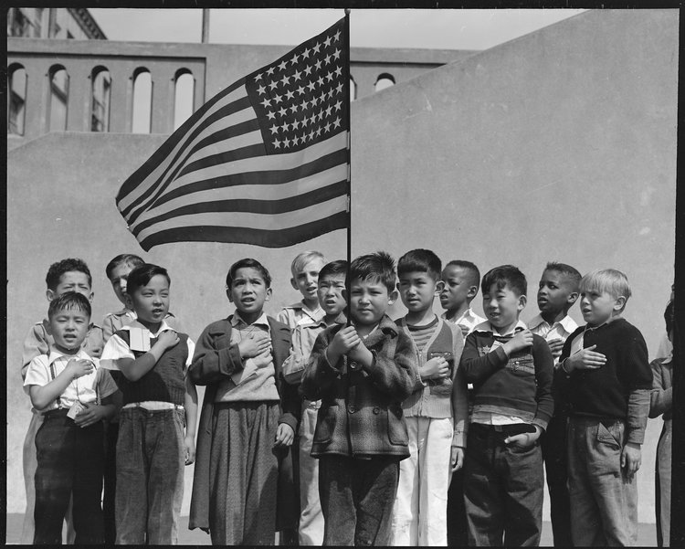 San Francisco, California. Flag of allegiance pledge at Raphael Weill Public School, Geary and Buchanan Streets. Children in families of Japanese ancestry were evacuated with their parents and will be housed for the duration in War Relocation Authority centers where facilities will be provided for them to continue their education.