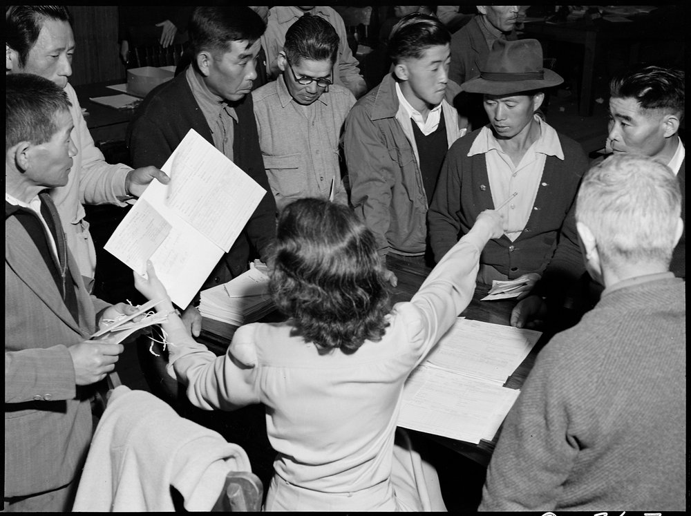 Byron, California. These field laborers of Japanese ancestry at Wartime Civil Control Administration Control Station are receiving final instructions regarding their evacuation to an Assembly center in three days.