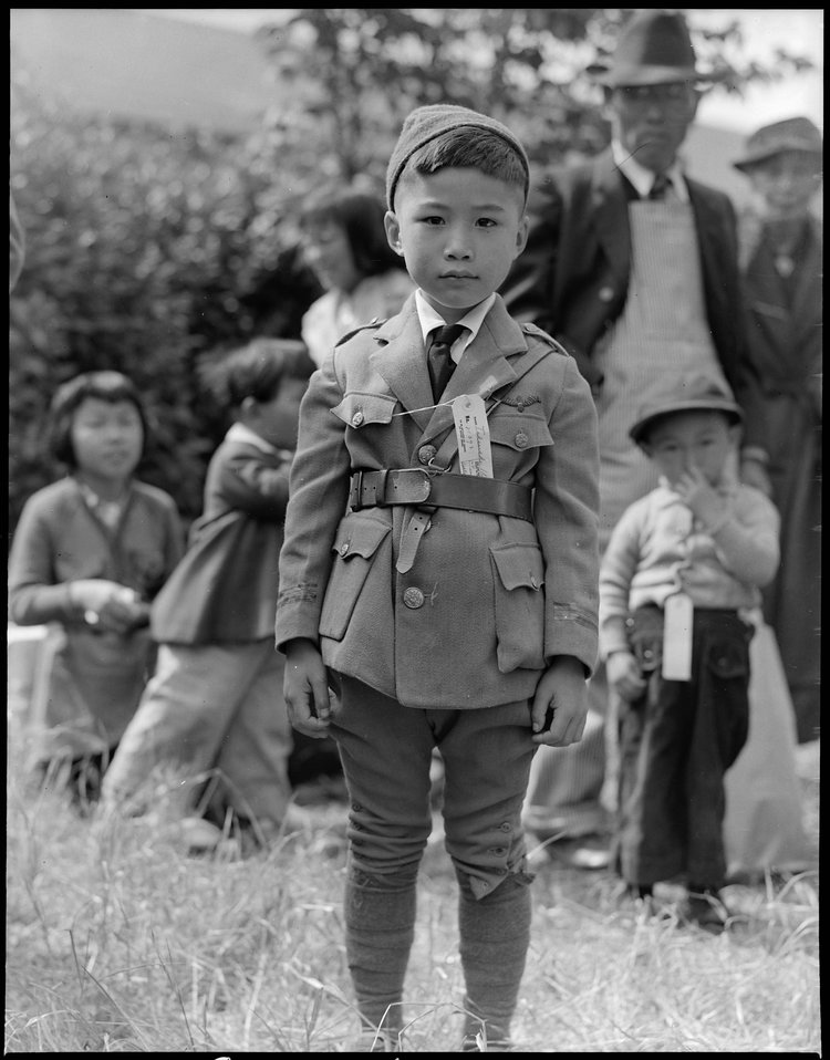 Centerville, California. This youngster is awaiting evacuation bus. Evacuees of Japanese ancestry will be housed in War Relocation Authority centers for the duration.